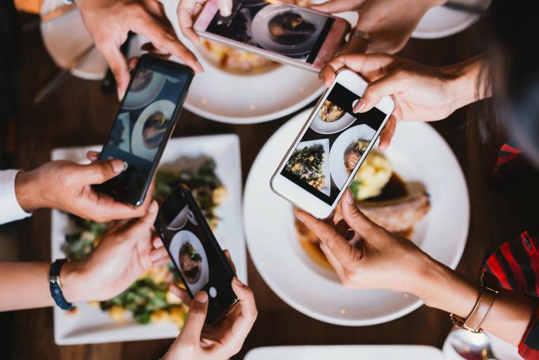People taking photos of food dishes