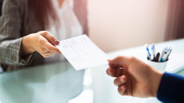 woman handing cheque