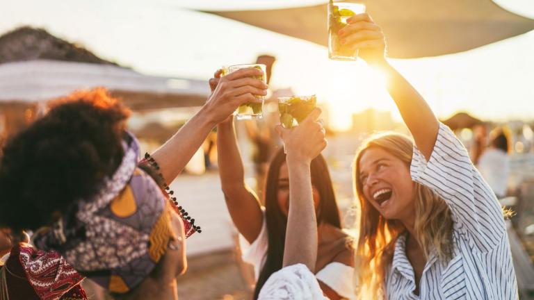 women drinking at bar at sunset
