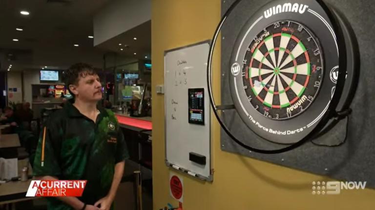 man looking at darts board