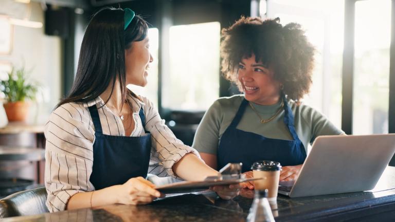 woman with laptop and woman with clipboard