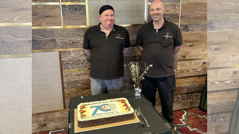men standing in front cake