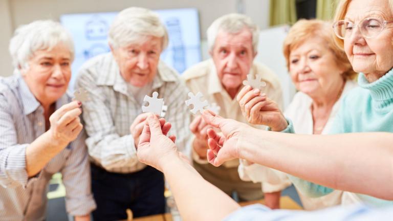 elderly people looking at a puzzle piece