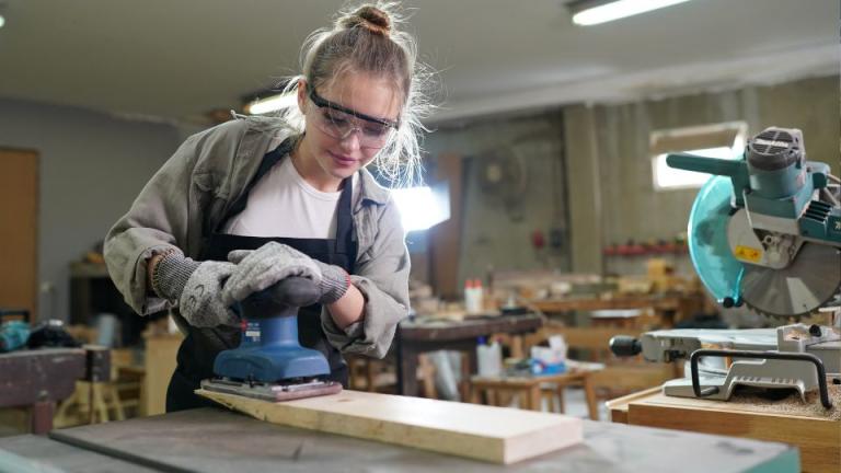 young girl sanding wood