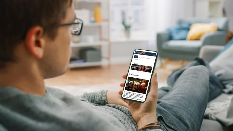 Man reading ClubLIFE on phone