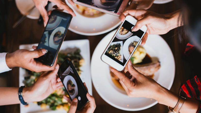 People taking photos of food dishes